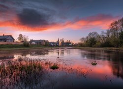 Różowo-niebieskie niebo i domy nad rzeką